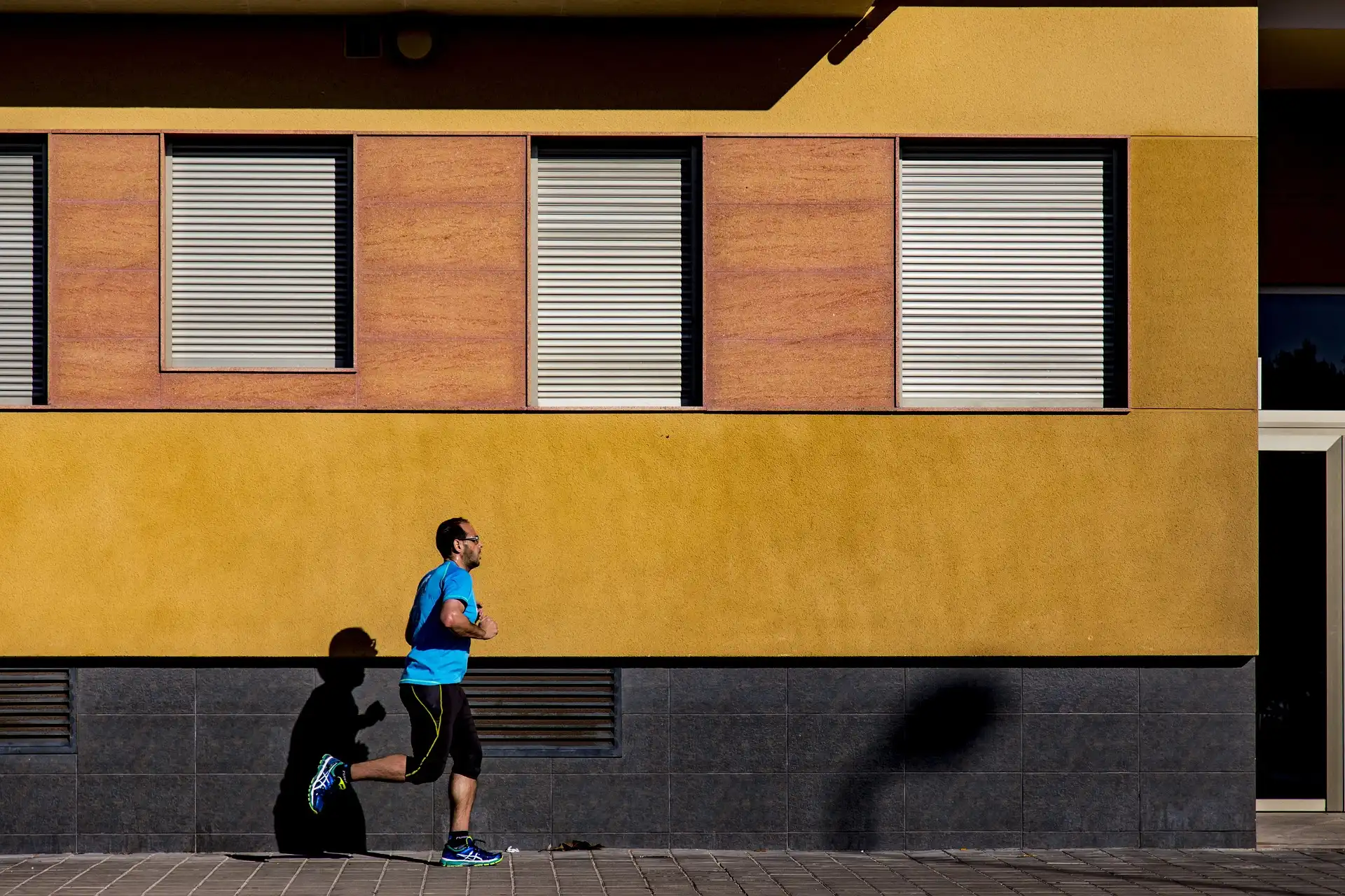 man running next to orange wall