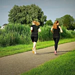 two black women shirts jugging on nature